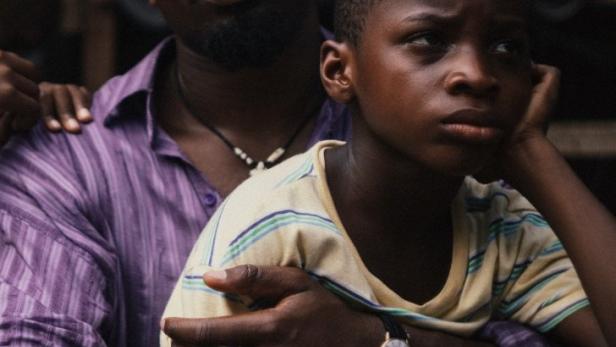 Ein Mann umarmt einen Jungen, der eine Armbanduhr trägt.