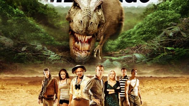 Das Filmplakat für „The Land That Time Forgot“ zeigt eine Gruppe von Menschen und einen Tyrannosaurus Rex.