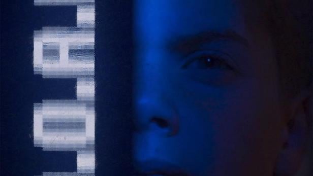 Ein Gesicht ist zur Hälfte von einem Schild mit dem Wort „TOTAL“ bedeckt.