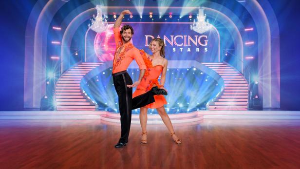 Ein Tanzpaar in orangefarbenen Kostümen auf der Bühne von „Dancing Stars“.