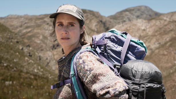 Eine Frau mit Rucksack wandert in den Bergen.