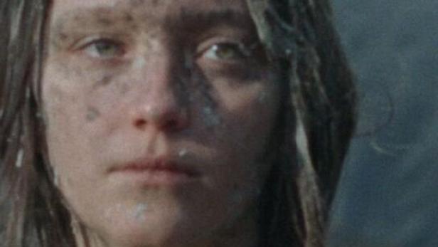 Das Gesicht einer jungen Frau ist mit Schmutz bedeckt.