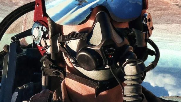 Ein Pilot der US-Luftwaffe mit Helm und Maske, im Visier spiegeln sich startende Kampfjets.