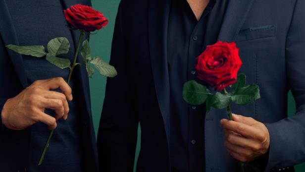 Zwei Männer in Anzügen halten jeweils eine rote Rose.