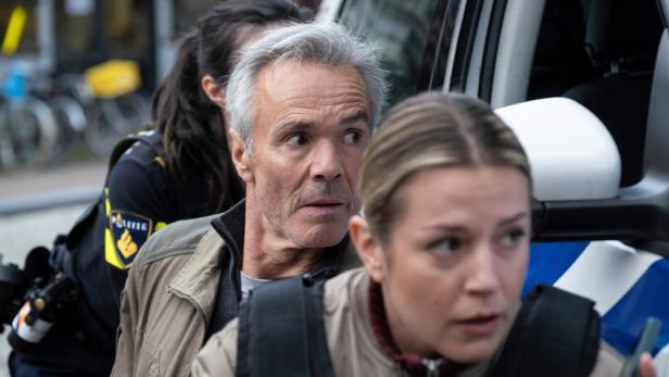 Ein Mann wird von zwei Polizisten in Amsterdam abgeführt.