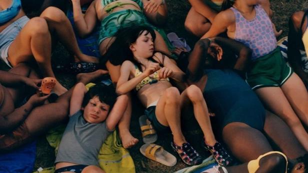 Das Filmplakat für „Summer Beats“ zeigt eine Gruppe Jugendlicher, die auf einer Wiese liegen.