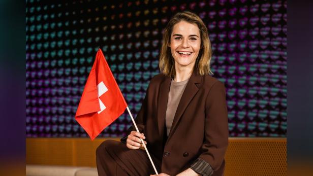 Hazel Brugger hält eine Schweizer Flagge in der Hand.