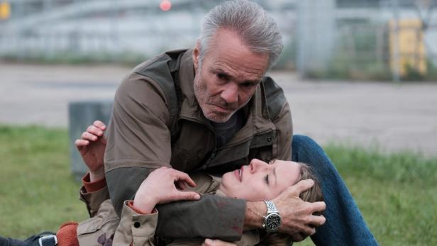 Ein Mann kümmert sich um eine verletzte Frau; möglicherweise eine Szene aus „Amsterdam-Krimi: Zeugin“.