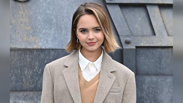 Ryan Kiera Armstrong trägt einen Blazer vor einem grauen Hintergrund.