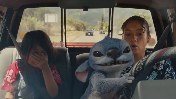 Ein Mädchen und eine Frau sitzen in einem Auto, während Stitch am Steuer sitzt.