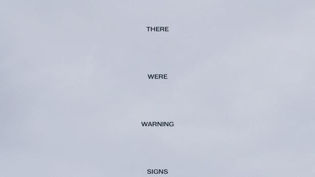 Das ausgebrannte Grenfell Tower-Gebäude unter einem bedeckten Himmel mit dem Text „Grenfell Uncovered“.