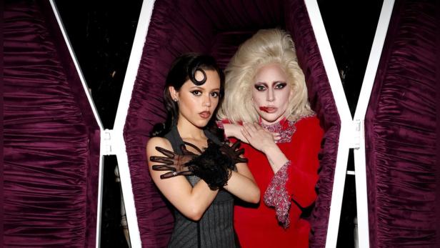 Jenna Ortega und Lady Gaga posieren in einem Sarg für ein Foto.