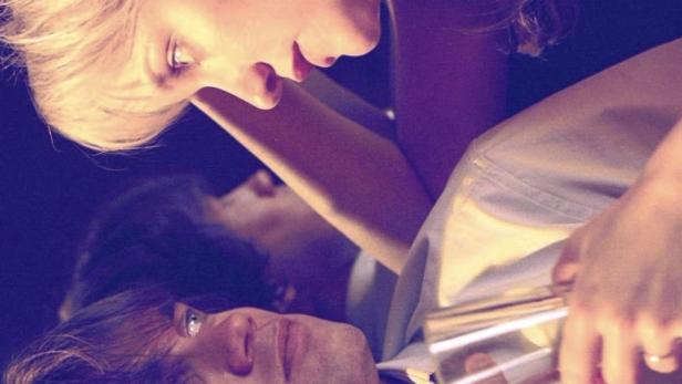 Eine Frau hält einem Mann zwei Glasröhrchen an den Hals.