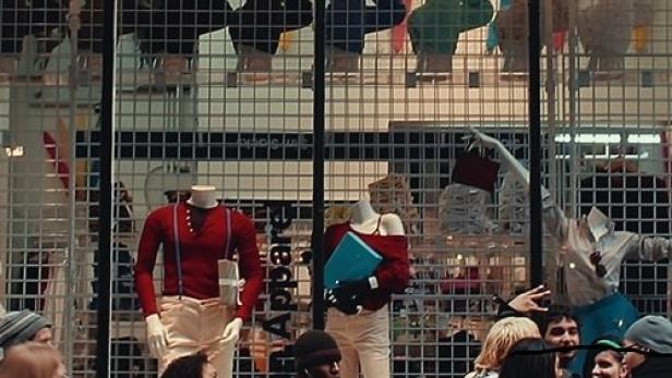 Passanten vor einem Schaufenster von American Apparel mit Schaufensterpuppen.