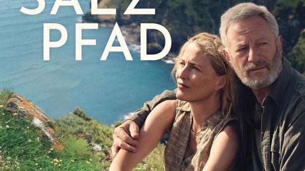 Das Filmplakat zu „Der Salzpfad“ mit Gillian Anderson und Jason Isaacs vor einer Küstenlandschaft.