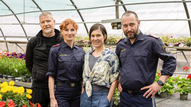Schauspieler und Polizisten am Set des Landkrimis „Kuh die weint“ in einem Gewächshaus.