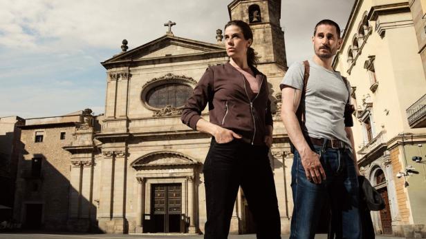 Zwei Personen stehen vor einer Kirche in Barcelona, möglicherweise für einen „Barcelona-Krimi“.