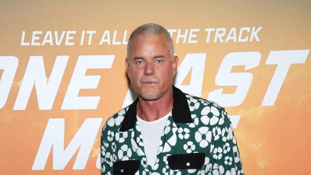 Eric Dane posiert vor einem Werbeplakat für „Fast & Furious“.