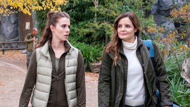 Zwei Frauen, vermutlich Tierärztinnen, gehen in einem Tierpark spazieren.