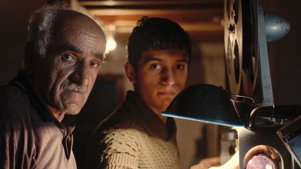 Das Filmplakat zu „Die Rückkehr des Filmvorführers“ zeigt zwei Männer und einen Filmprojektor.