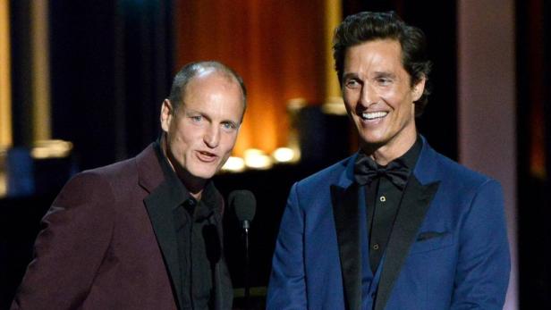 Woody Harrelson und Matthew McConaughey stehen auf einer Bühne.