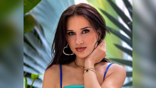 Vanessa Borck, bekannt aus „Prinzessin Charming“, posiert vor tropischen Pflanzen.