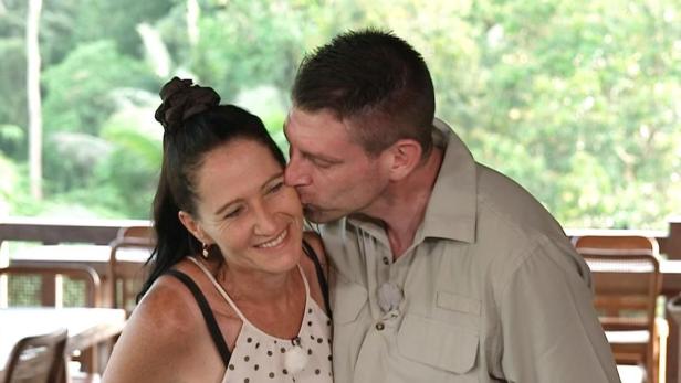 Ein Mann gibt einer lächelnden Frau einen Kuss auf die Wange.