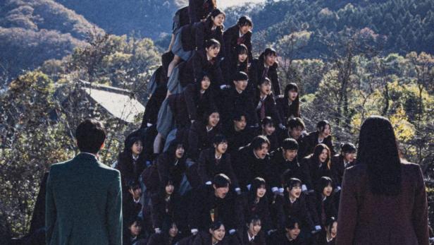 Das Filmplakat für „New Group“ zeigt eine Gruppe von Schülern, die eine Pyramide bilden.