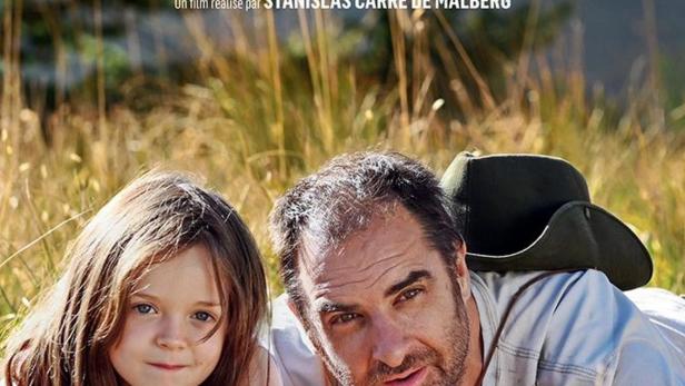 Das Filmplakat zu „Les Enchantés“ zeigt ein Mädchen und einen Mann, die im Gras liegen.