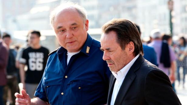 Commissario Brunetti und ein Mann in Anzug stehen vor einer Menschenmenge.