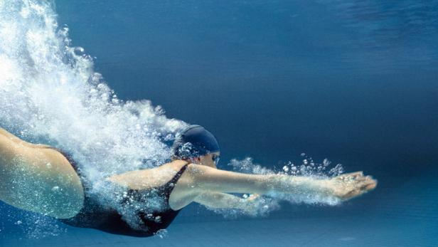 Eine Schwimmerin taucht im Filmplakat zu „22 Bahnen“ ins Wasser.