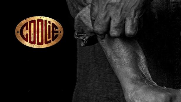 Ein Mann mit goldenem Armreif und dem „Coolie“-Logo im Vordergrund.