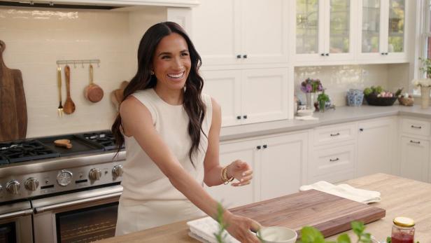 Meghan Markle lächelt in einer hellen Küche.