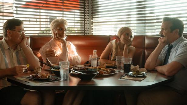 Vier Personen sitzen an einem Tisch in einem Restaurant.