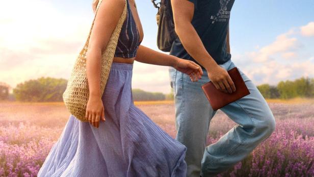 Ein junges Paar geht durch ein Lavendelfeld, wie auf dem Filmplakat zu „The Map That Leads to You“.