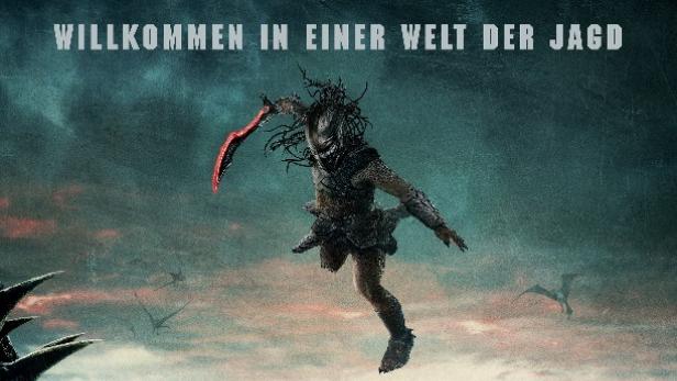 Ein Predator springt mit einer Klinge in der Hand vor einer unwirklichen Landschaft auf dem Filmplakat zu „Predator: Badlands“.