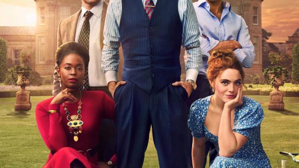 Das Gruppenbild der Besetzung von „Rivals“ vor einem Herrenhaus bei Sonnenuntergang.