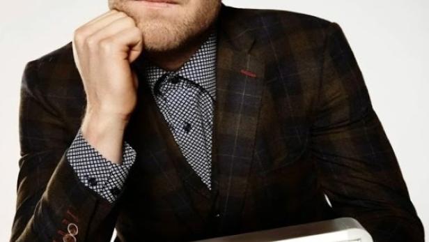 Ein Mann im Anzug hält ein Schild mit der Aufschrift „ON AIR“.