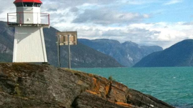 Ein Leuchtturm steht auf einer felsigen Küste mit Bergen und dem Schriftzug „mareTV“ im Hintergrund.