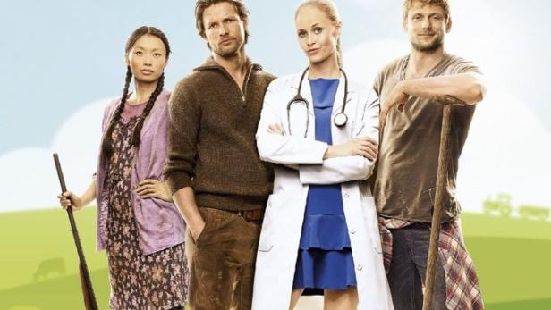 Das Filmplakat zu „Doc meets Dorf“ zeigt vier Personen auf einer grünen Wiese.