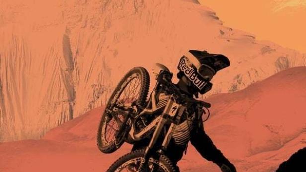 Ein Mountainbiker trägt sein Fahrrad auf einem Berg, im Hintergrund der Schriftzug „Where the Trail Ends“.