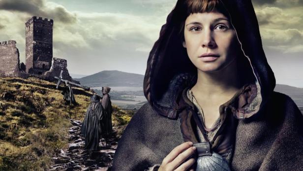 Das Filmplakat für „Die Pilgerin“ zeigt eine junge Frau mit Kapuze vor einer mittelalterlichen Landschaft.