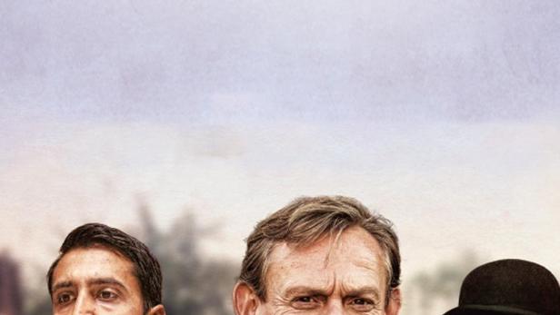 Das Filmplakat für „Arthur & George“ zeigt drei Männer in Anzügen vor einem verschwommenen Hintergrund.