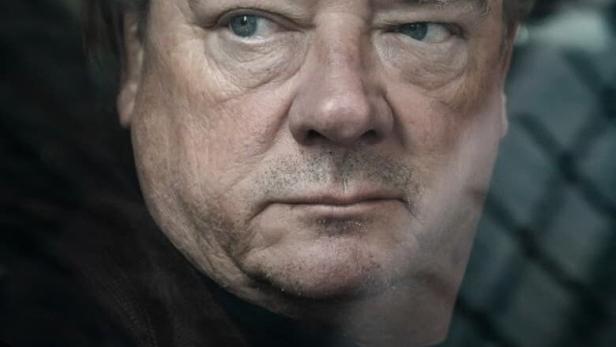 Das Filmplakat zu „Glauben“ von Ferdinand von Schirach zeigt einen Mann mit ernstem Blick.