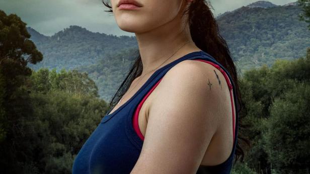 Eine junge Frau mit blutiger Hand vor einer Flusslandschaft, vermutlich ein Filmposter für „Savage River“.