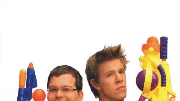 Zwei Männer stehen Rücken an Rücken und halten bunte Wasserpistolen.