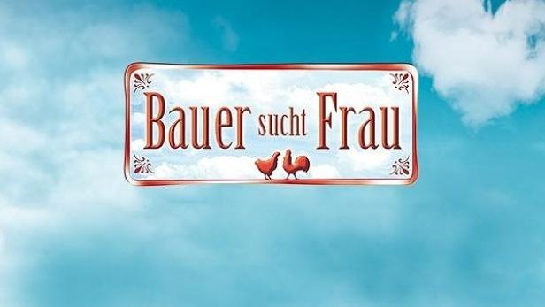 Das Logo der Fernsehsendung „Bauer sucht Frau“ vor blauem Himmel und grüner Wiese.