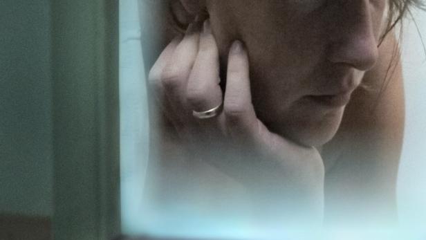 Das Filmplakat für „Zwei Mütter“ zeigt eine Frau, die nachdenklich ihr Gesicht berührt.