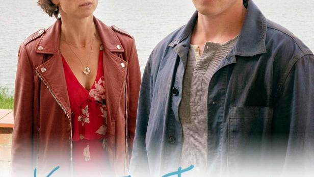 Das Filmplakat zu „Katie Fforde: Emmas Geheimnis“ zeigt eine Frau und einen Mann vor einer Küstenlandschaft.