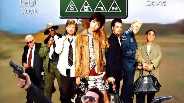 Das Filmplakat für „29 Palms“ zeigt eine Gruppe von bewaffneten Personen in der Wüste.